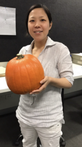 Wysa user wearing cream shirt and pants, smiling holding a pumpkin