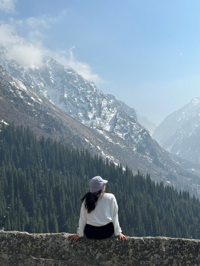 Real Wysa app user sat outside in nature looking out to the mountains.