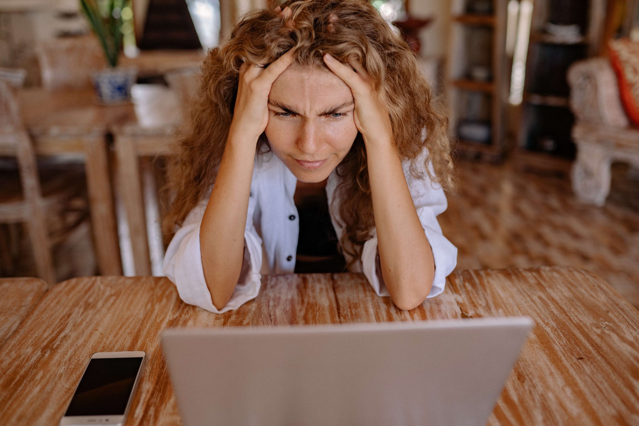 a frustrated woman looking at her laptop